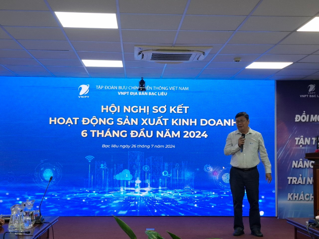 A person standing in front of a large blue sign

Description automatically generated