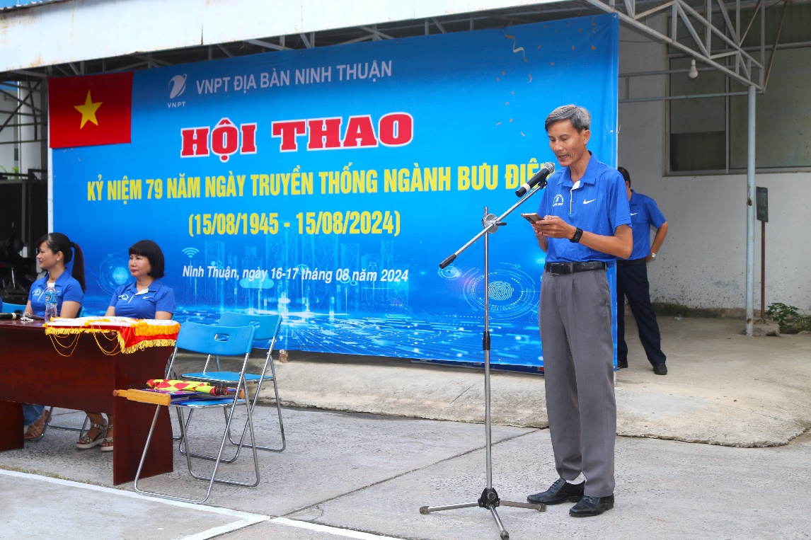 A person standing in front of a banner
Description automatically generated