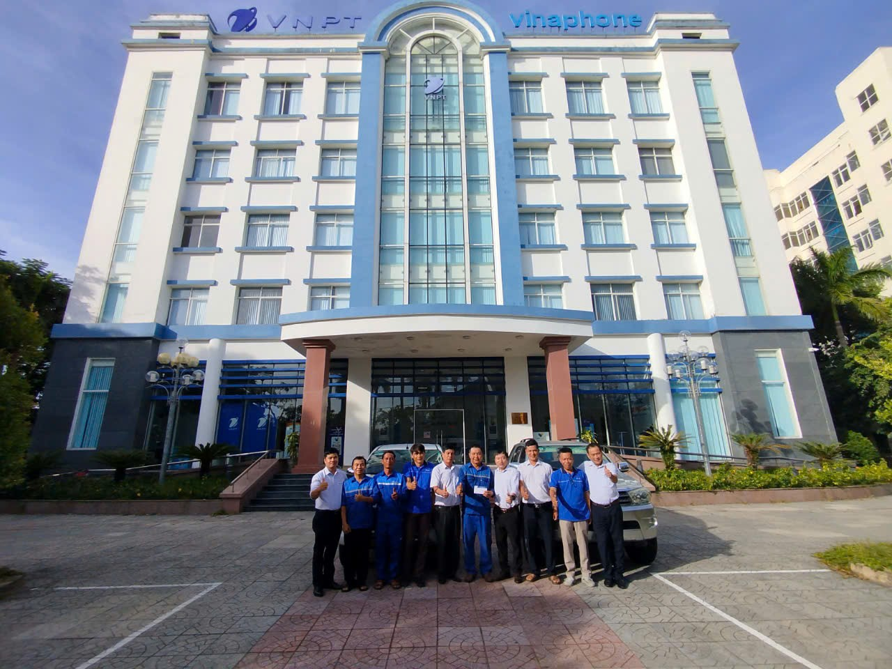 A group of people standing in front of a building

Description automatically generated