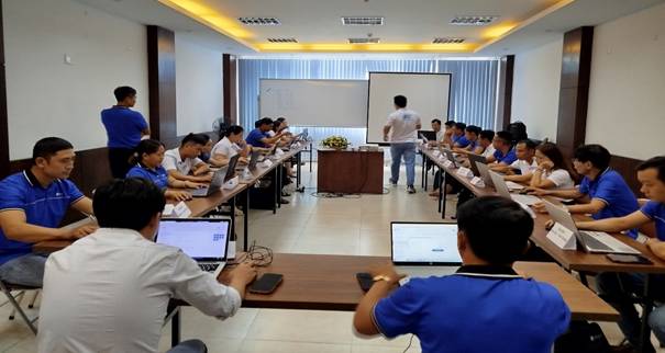 A group of people in a room with laptops
Description automatically generated
