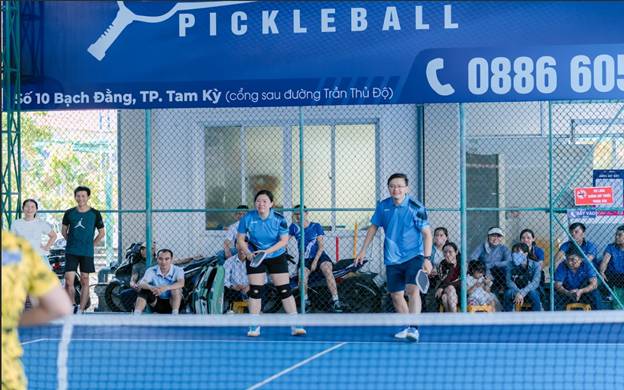 People playing tennis in a court
Description automatically generated
