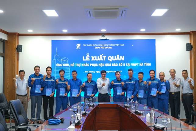 A group of people standing in front of a table with blue signs

AI-generated content may be incorrect.