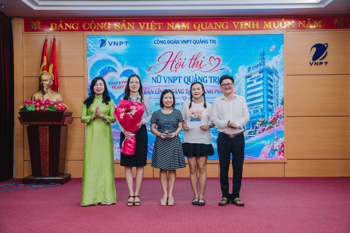 A group of people standing in front of a banner
Description automatically generated