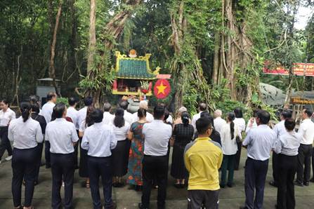 A group of people standing in front of a shrine

Description automatically generated