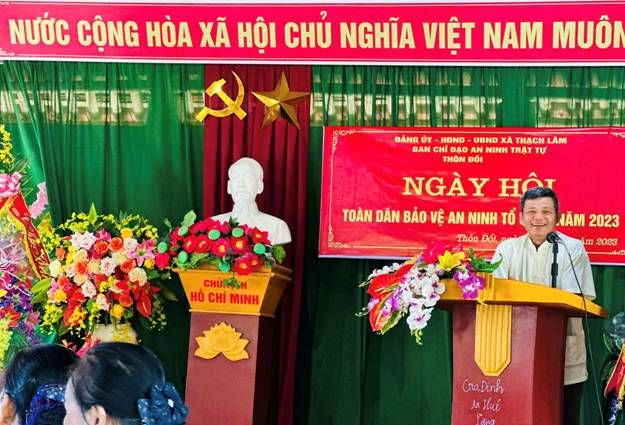 A group of people standing in front of a red banner

Description automatically generated