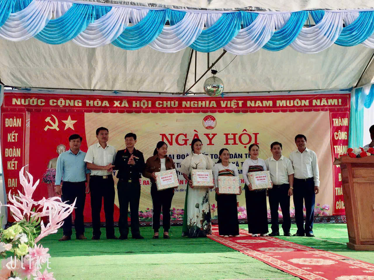 A group of people standing in front of a banner
Description automatically generated