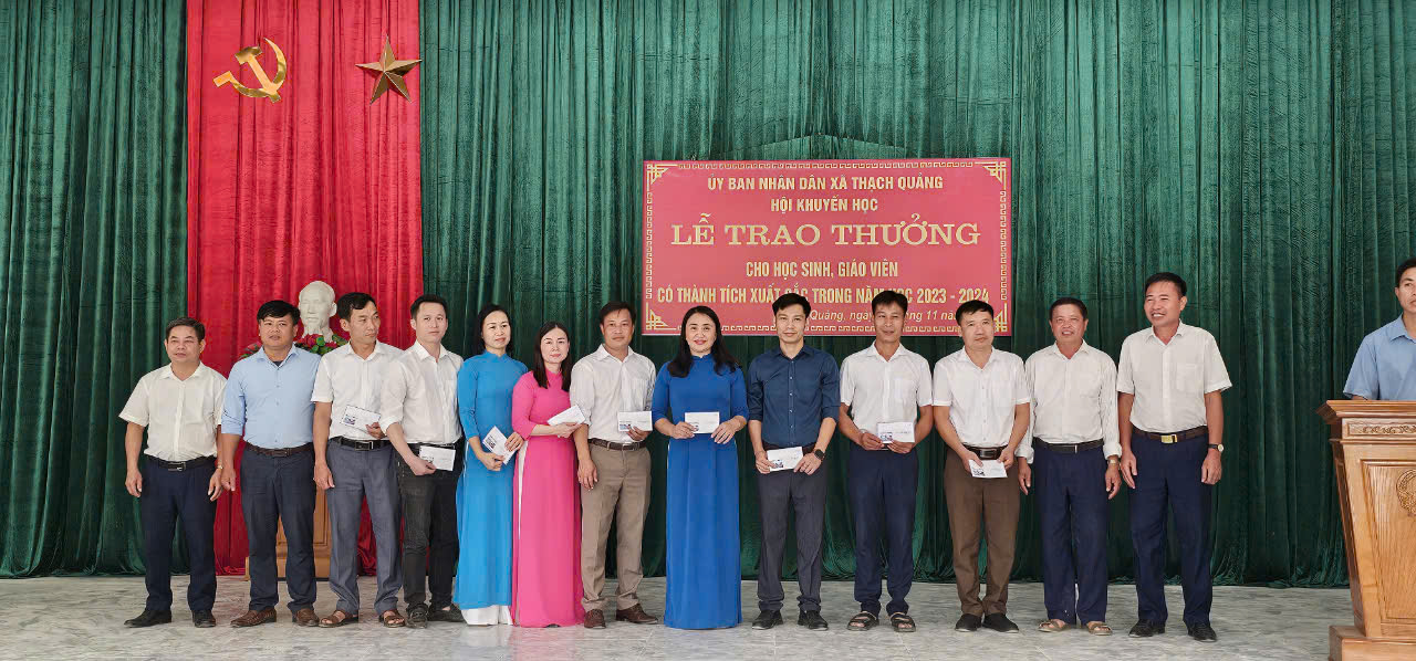 A group of people standing in front of a curtain
Description automatically generated