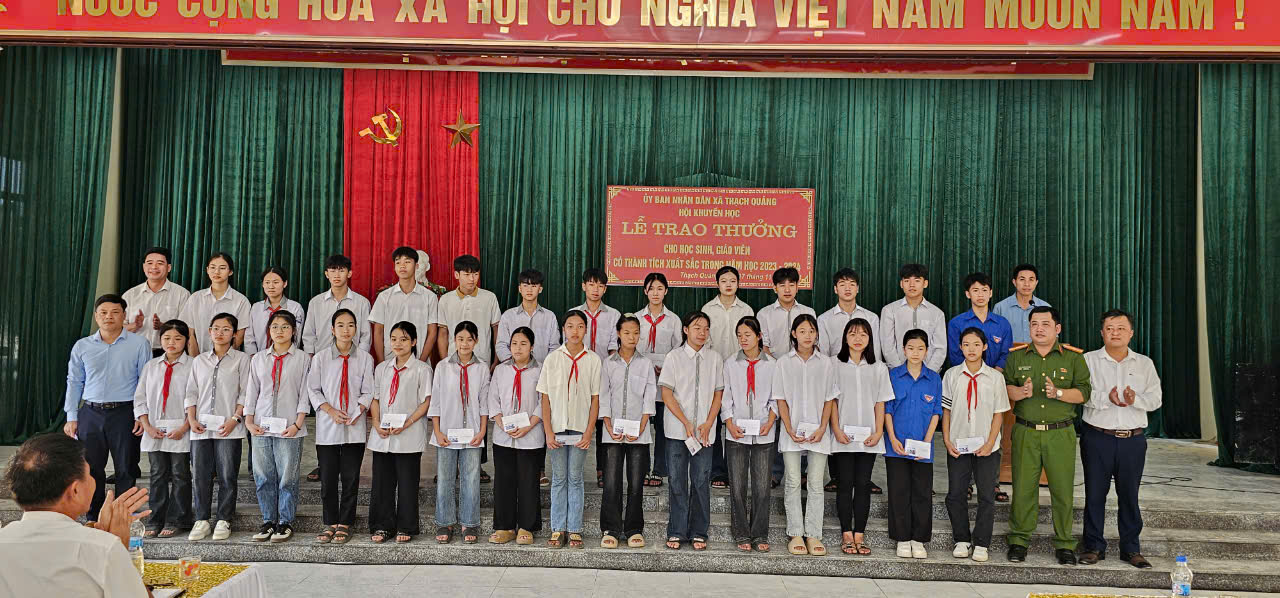 A group of people standing in front of a stage
Description automatically generated