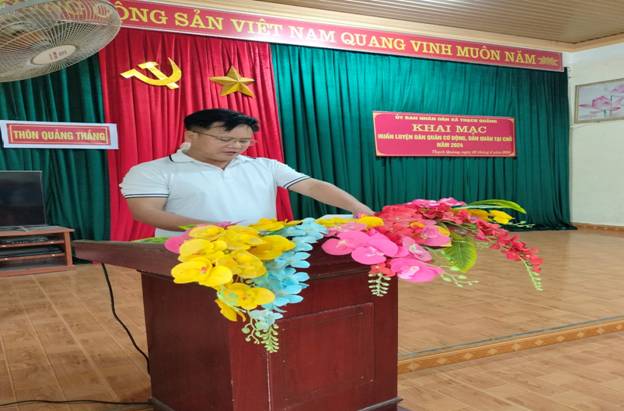 A person standing at a podium with flowers

Description automatically generated