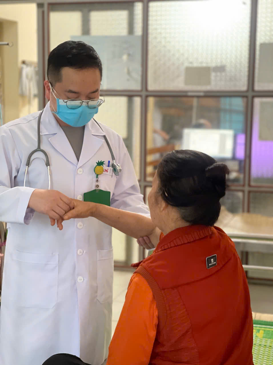 A doctor wearing a mask and holding a person's hand
AI-generated content may be incorrect.