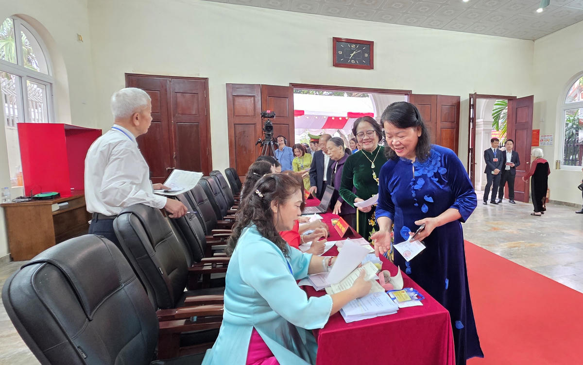 Các cử tri hào hứng nhận phiếu bầu từ ban bầu cử... Ảnh: Nguyễn Chung.