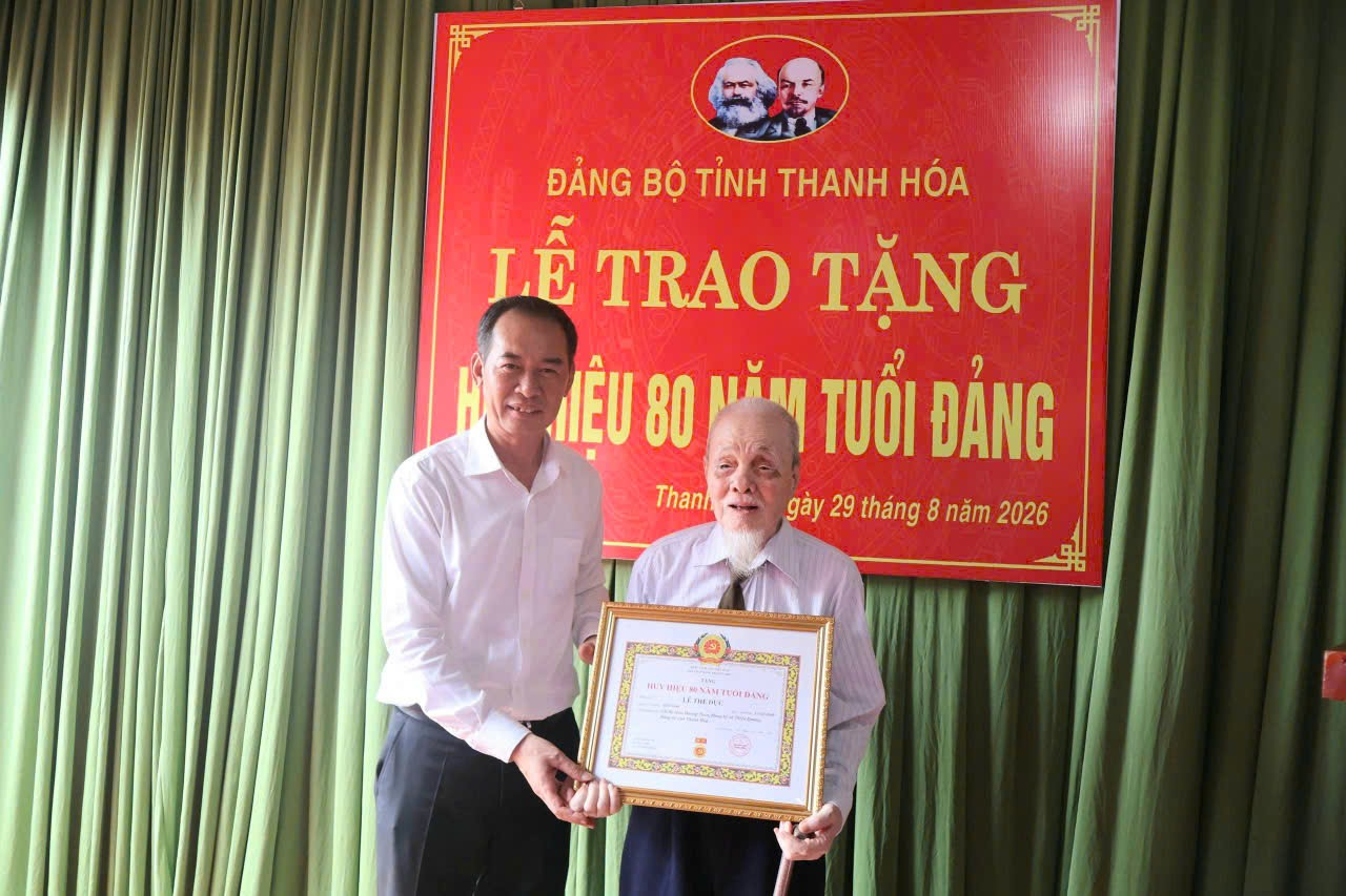 Đồng chí Phó Bí thư Tỉnh uỷ, Chủ tịch Uỷ ban MTTQ tỉnh Trịnh Tuấn Sinh trao Huy hiệu 80 năm tuổi Đảng cho đảng viên Lê Thế Dực