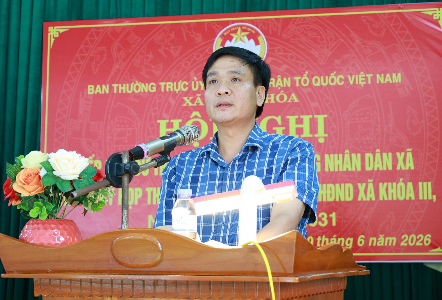 A person standing at a podium with a microphone
Description automatically generated