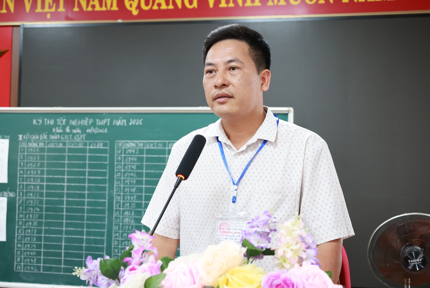 A person standing in front of a microphone
Description automatically generated