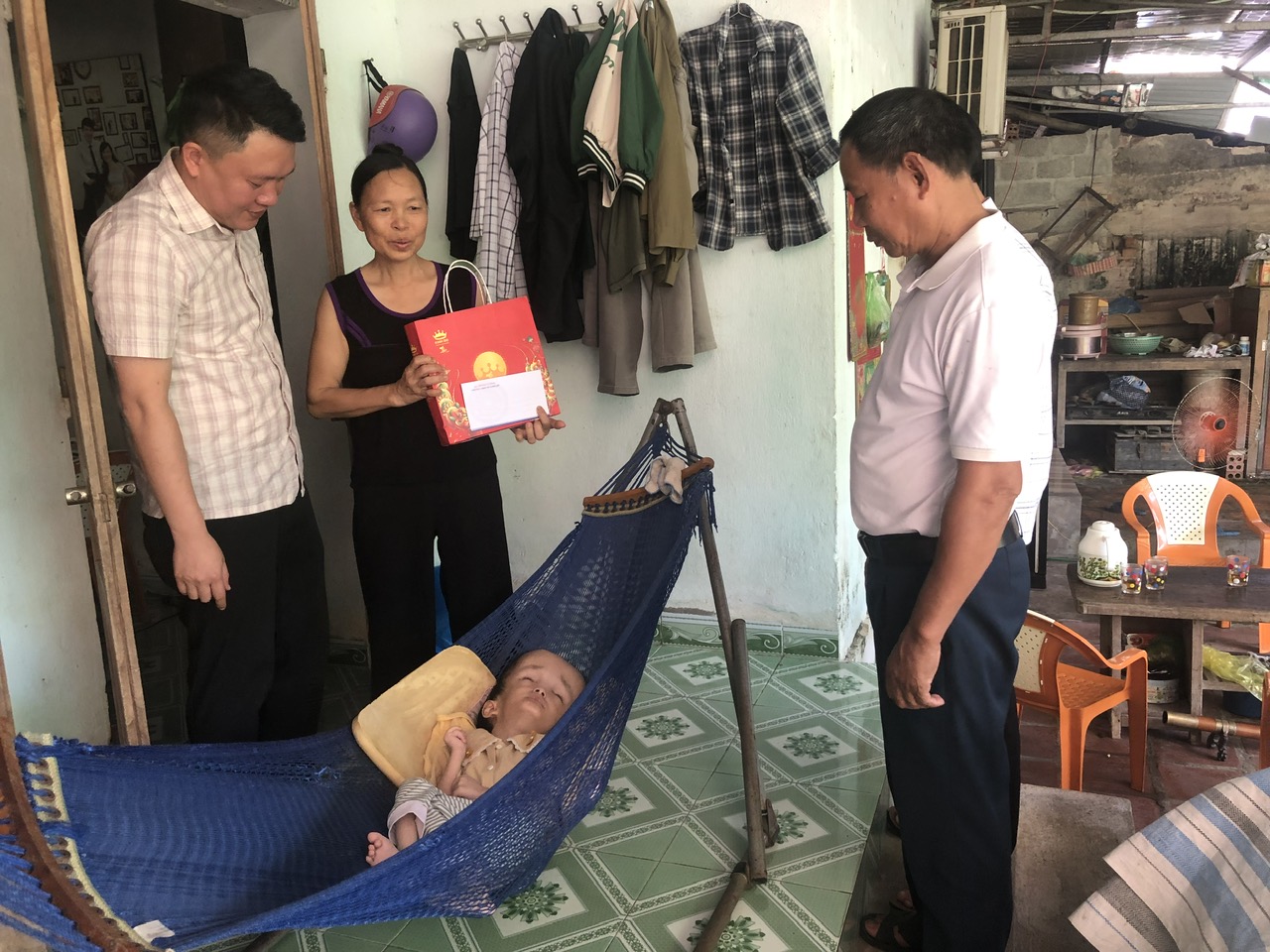 A group of people standing around a baby in a hammock
AI-generated content may be incorrect.