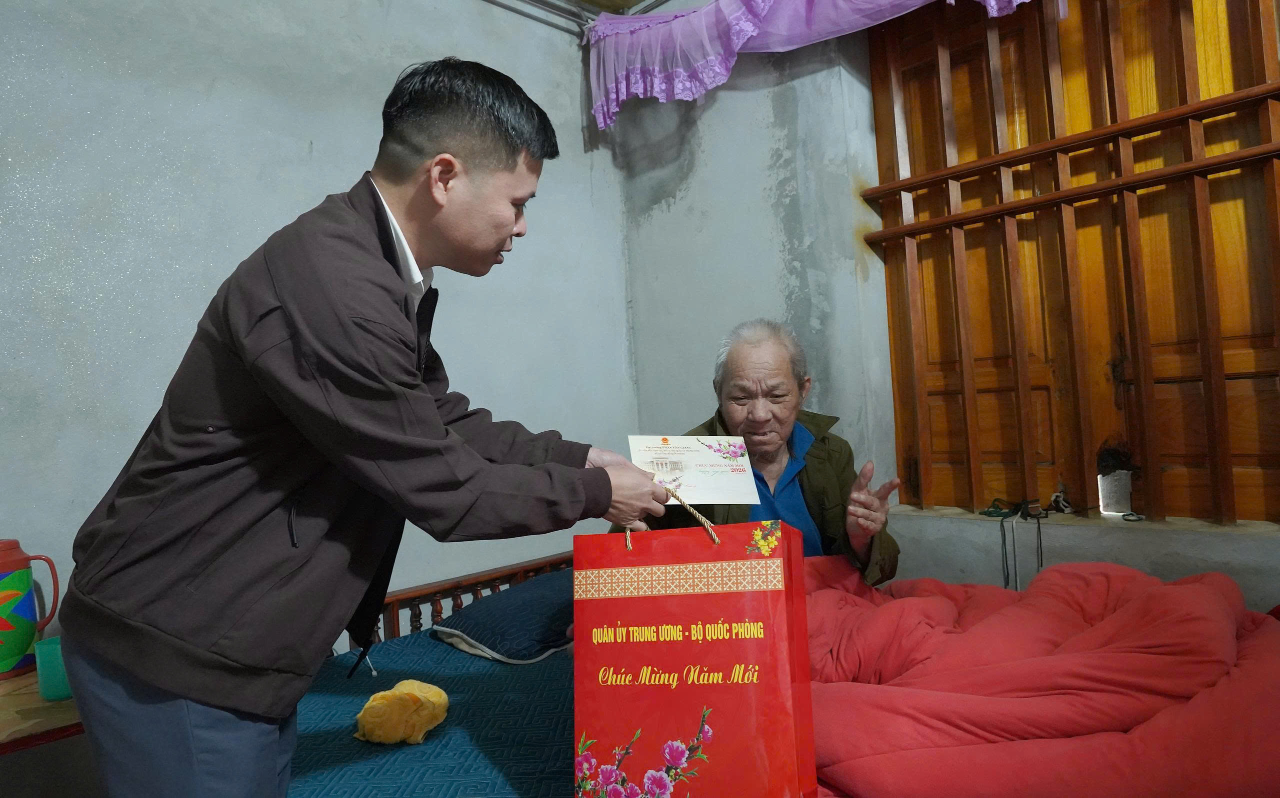 Đồng chí Nguyễn Huy Hà, Ủy viên Ban Thường vụ Đảng ủy, Phó Chủ tịch HĐND xã Yên Trạch  trao quà Tết cho người có công tại xóm Khe Nác và xóm Kẻm.