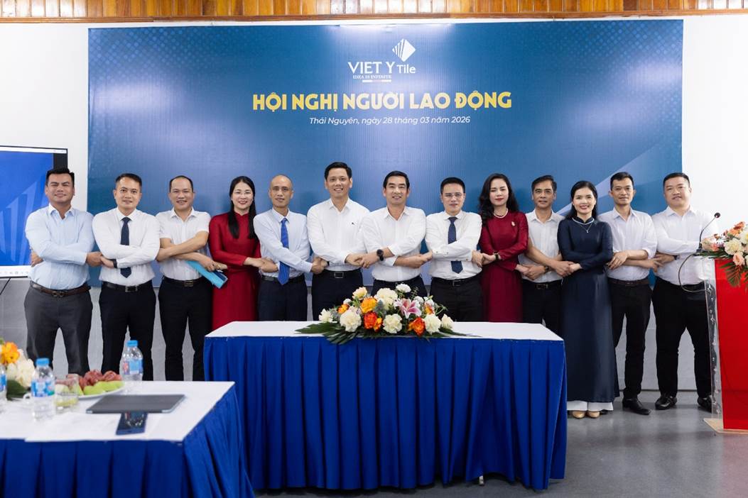A group of people standing in front of a blue table
Description automatically generated