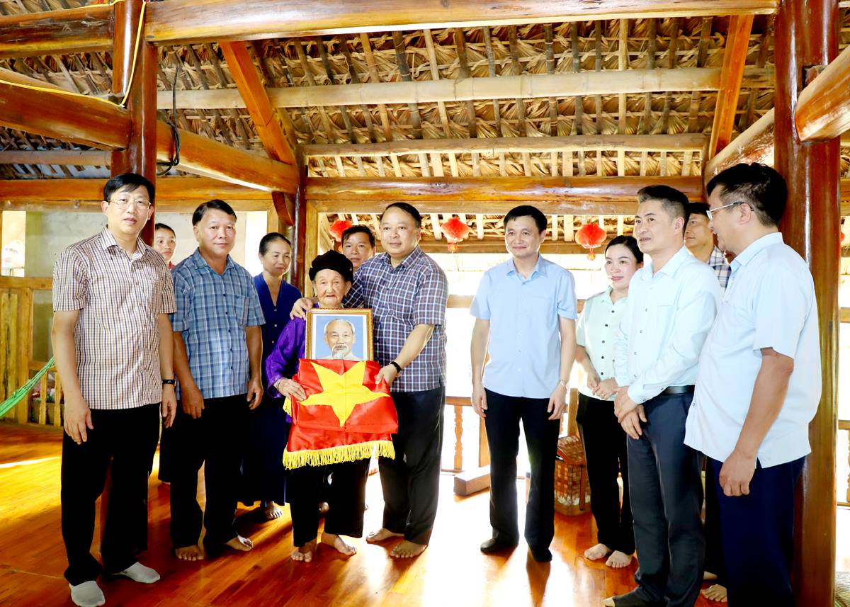Chủ tịch UBND tỉnh Phan Huy Ngọc tặng cờ Tổ quốc, ảnh chân dung Chủ tịch Hồ Chí Minh cho hộ bà Hoàng Thị Tô, xã Đông Thành.