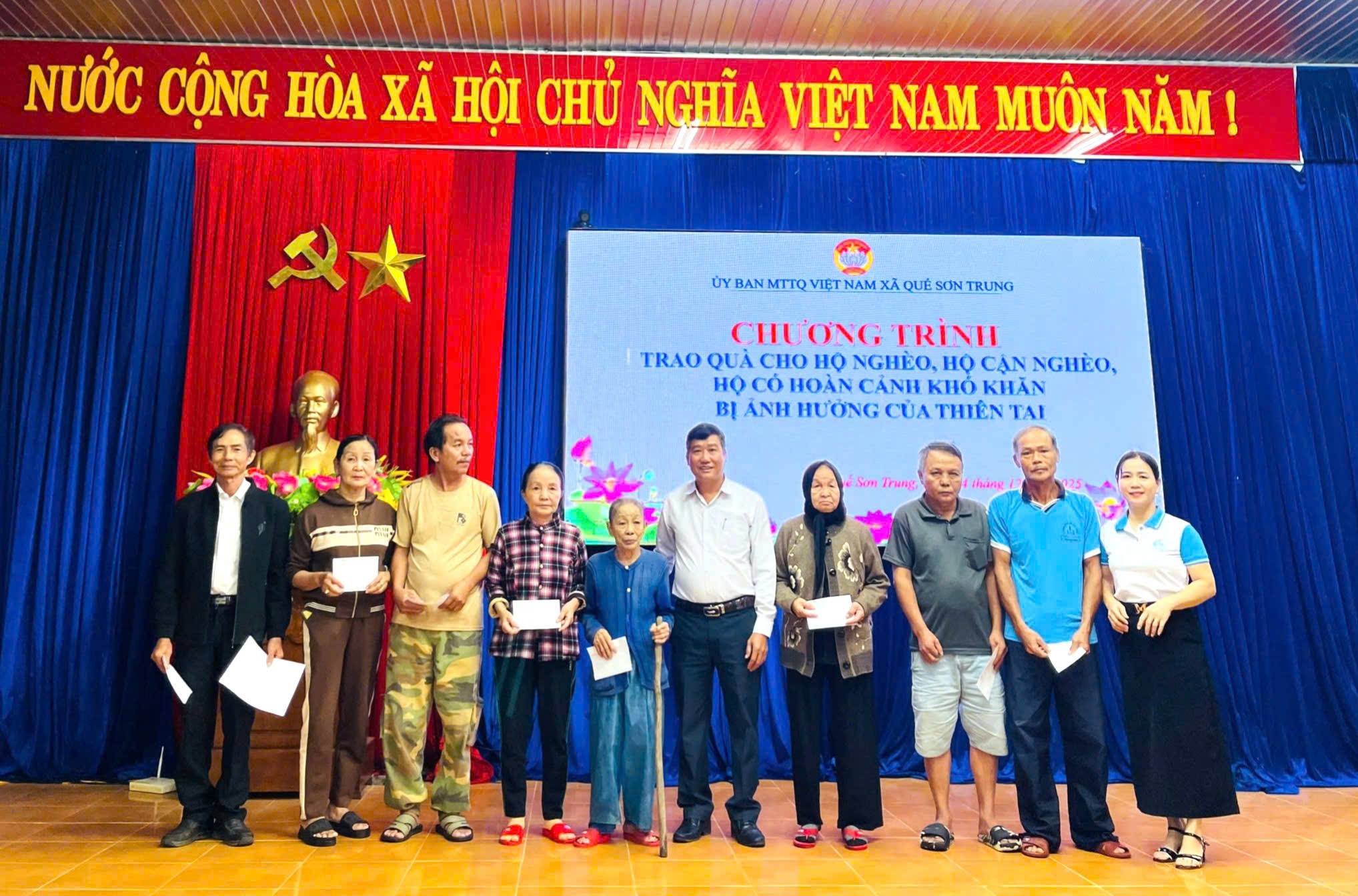 Chủ tịch Uỷ ban MTTQ Việt Nam xã Quế Sơn Trung trao quà cho người dân khó khăn.