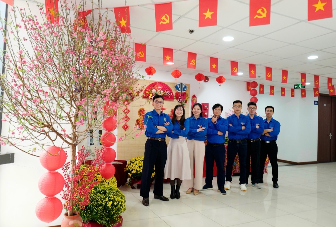 A group of people standing in a room with flags and flowers
AI-generated content may be incorrect.