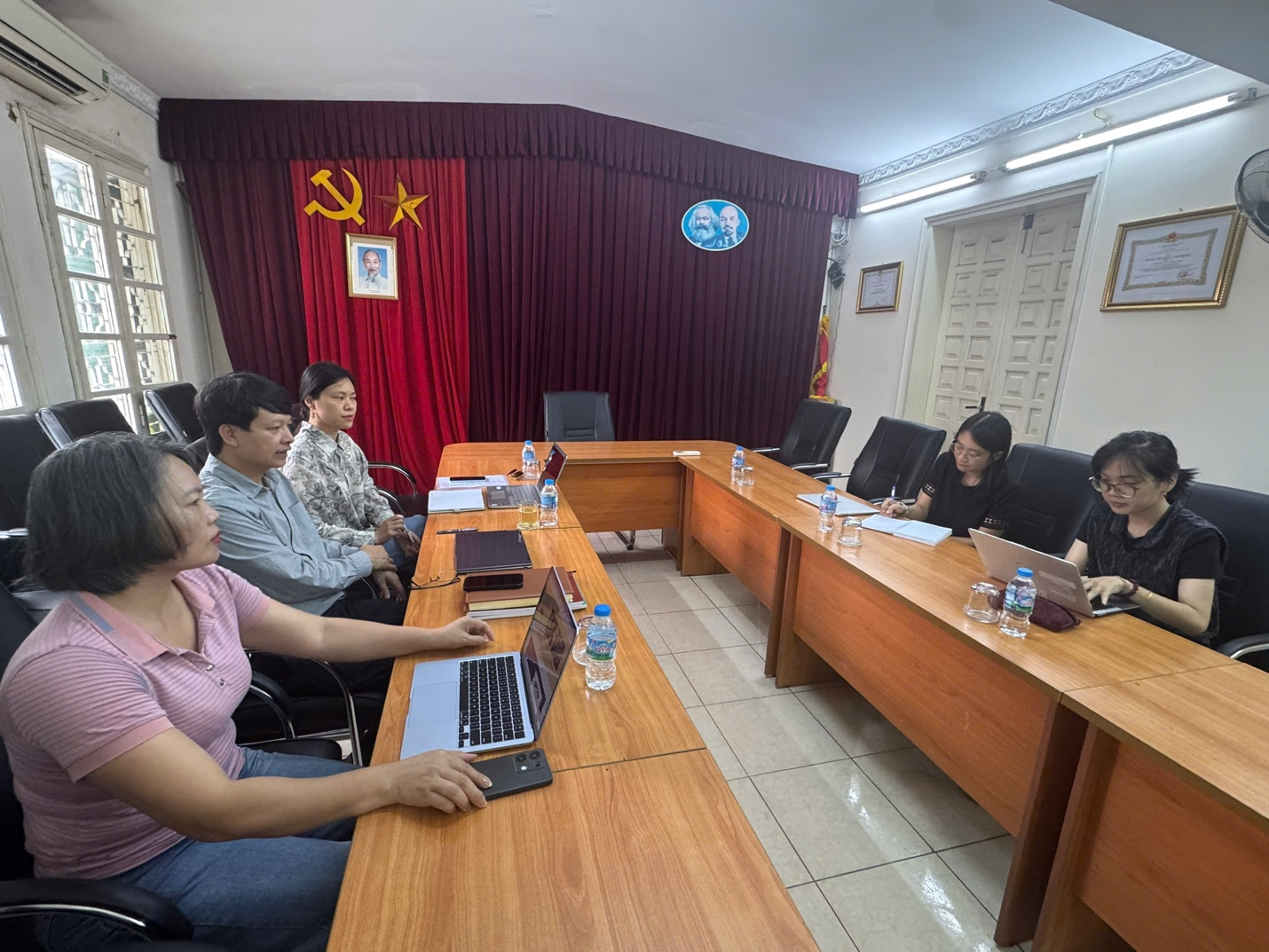 A group of people sitting at a table with laptopsAI-generated content may be incorrect.