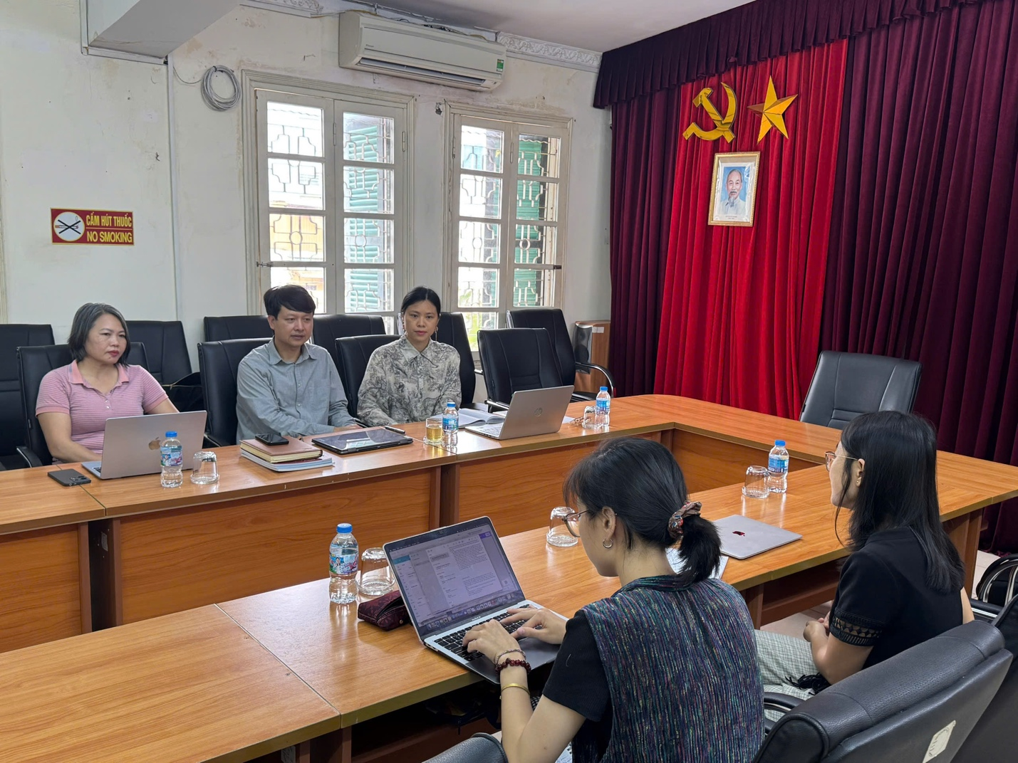A group of people sitting around a table with laptopsAI-generated content may be incorrect.